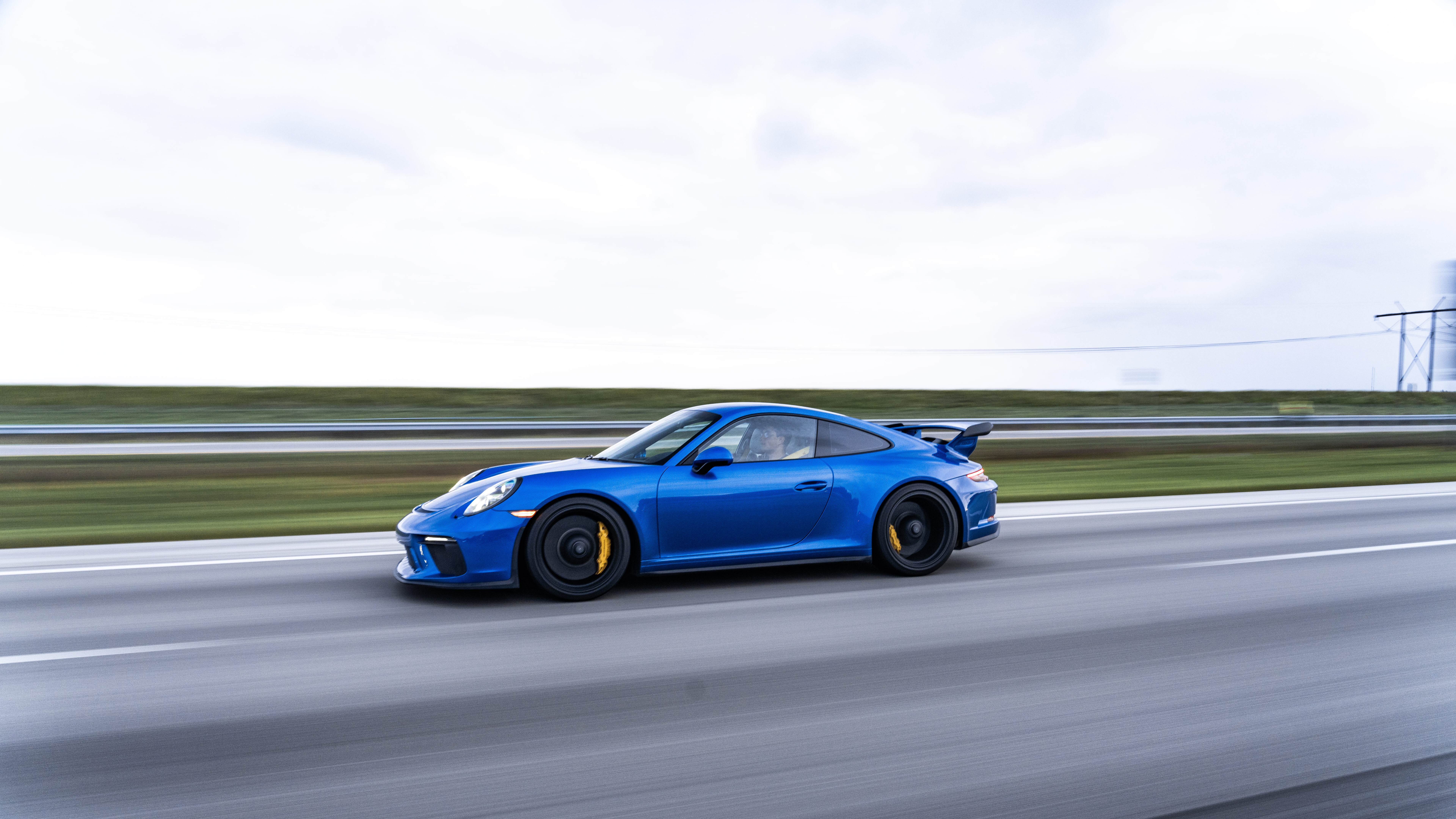 Eine hochauflösende Aufnahme eines Porsche GT3 RS Sportwagens, die das charakteristische aerodynamische Karosserie-Kit und die rennsportliche Silhouette des Fahrzeugs zeigt.