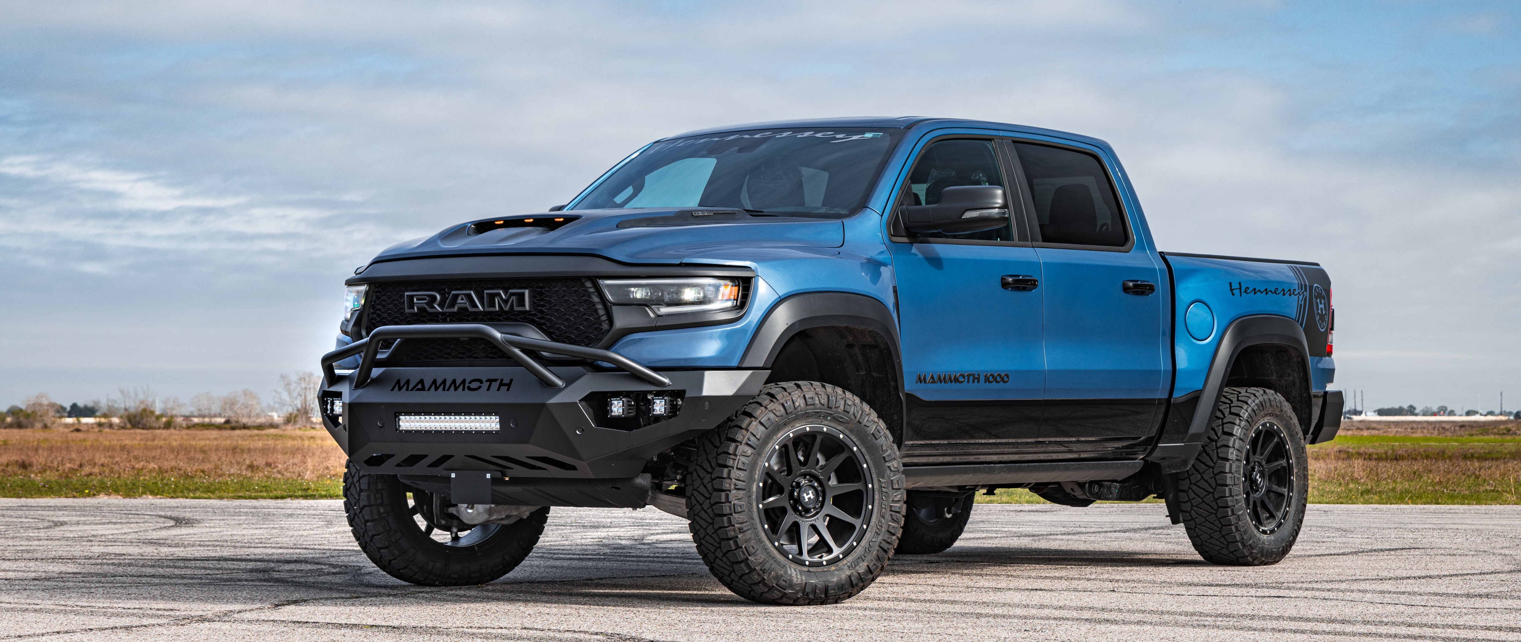 Ein riesiger, hochgelegter Hennessey Mammoth 1000 Dodge Ram Pick-up mit auffälligen Geländewagen-Modifikationen und einer verbreiterten Karosserie.