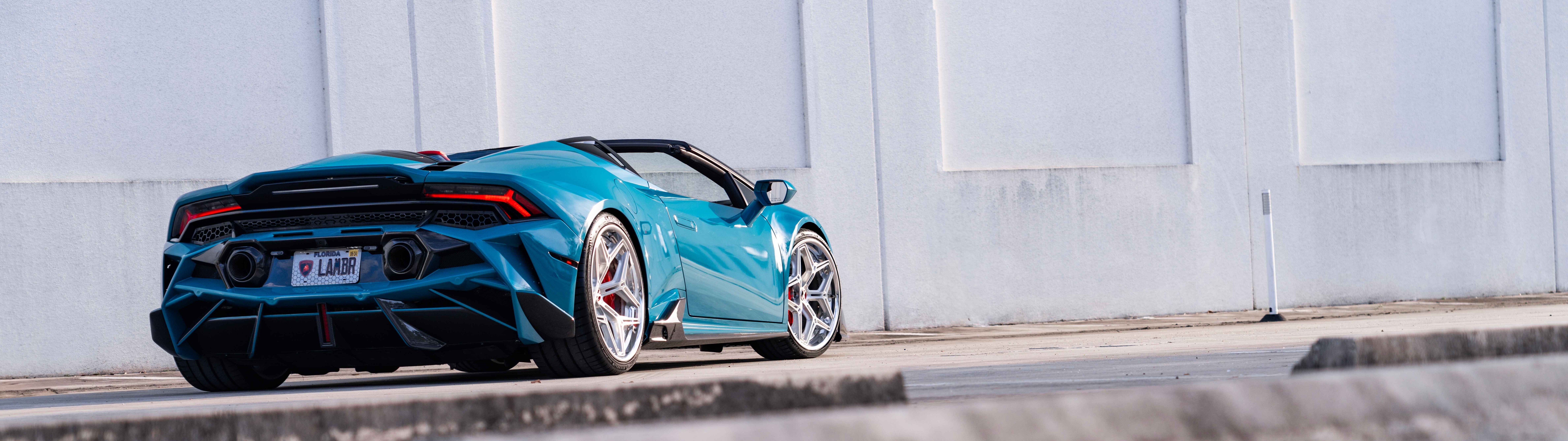 Eine detaillierte Ansicht eines Lamborghini Huracan Evo, die seine markante, aerodynamisch gestaltete Karosserie und die elegante Silhouette dieses Supersportwagens zeigt.