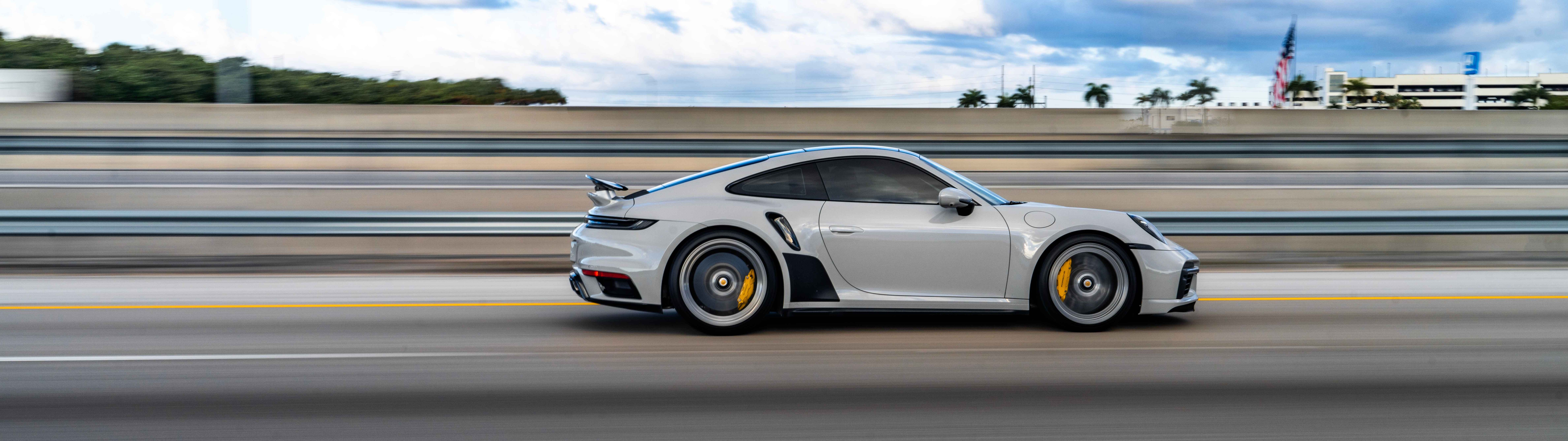 Eine Nahaufnahme eines luxuriösen Porsche-Sportwagens mit elegantem Design und metallisch glänzender Lackierung.