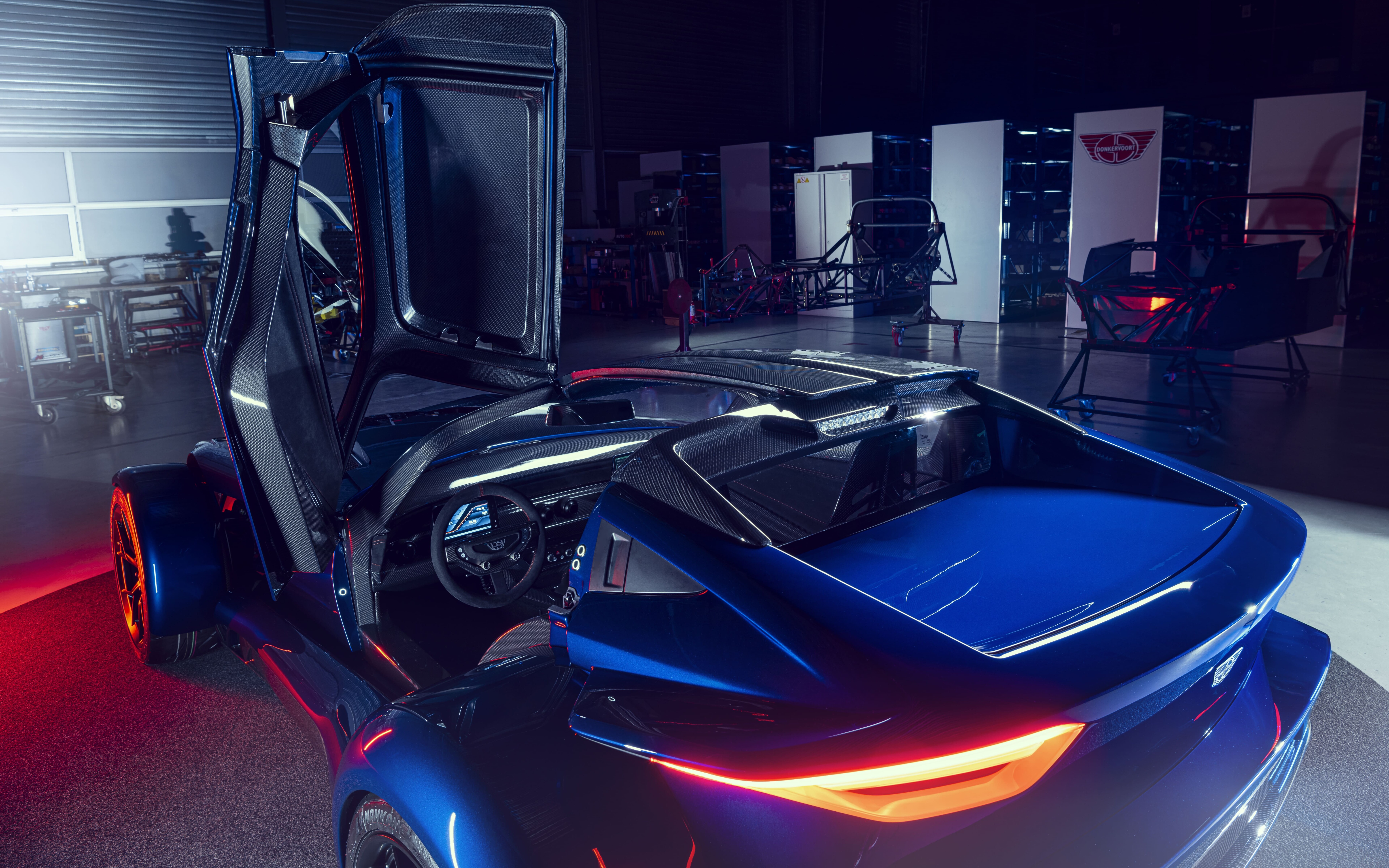 Ein elegantes, metallisch silbernes Sportauto, das das sanfte Licht eines Fotostudios vor einem dunklen Hintergrund reflektiert.